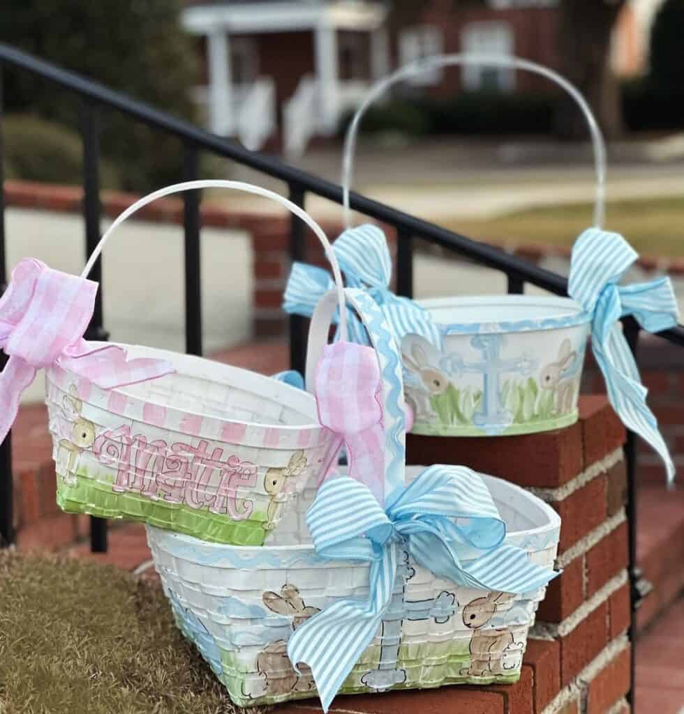 Charming Easter egg basket with pink and blue bows. Personalized outside of the basket with names and drawing of bunnies, flowers, cross in pastel colors