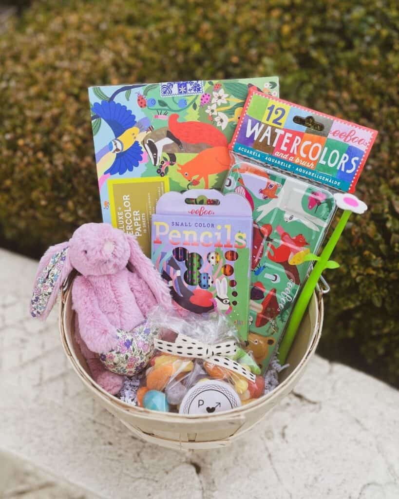 Basket filled with coloring pages, watercolor book, pencils, flower, bunnies soft toy perfect for mini artist