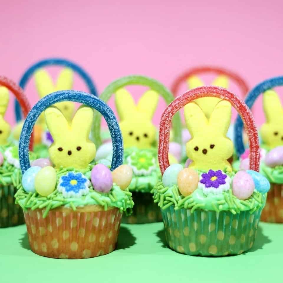 Easter theme vanilla cupcake decorated with marshmallows chicks, egg candies, grass frosting 